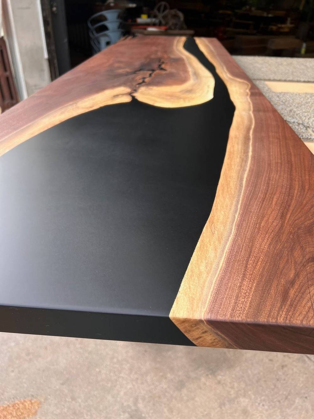 Overhead view of the walnut table top showing grain and epoxy fill