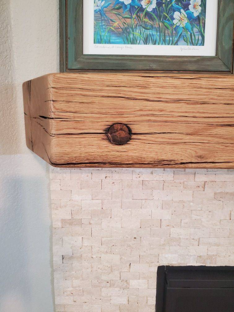 Hand-hewn barn beam mantel showing axe marks across the face