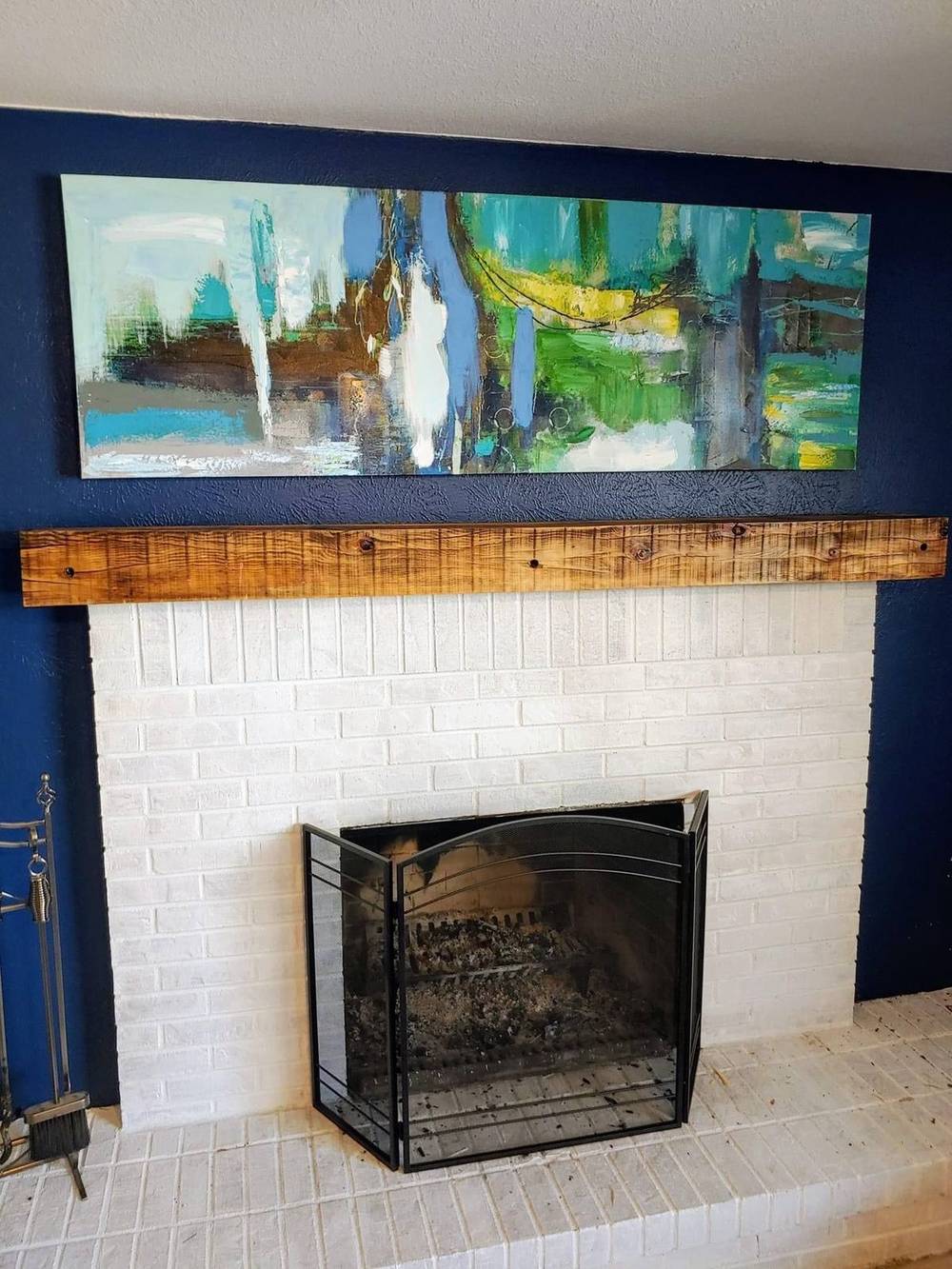 Reclaimed mantel above a blue tile fireplace surround