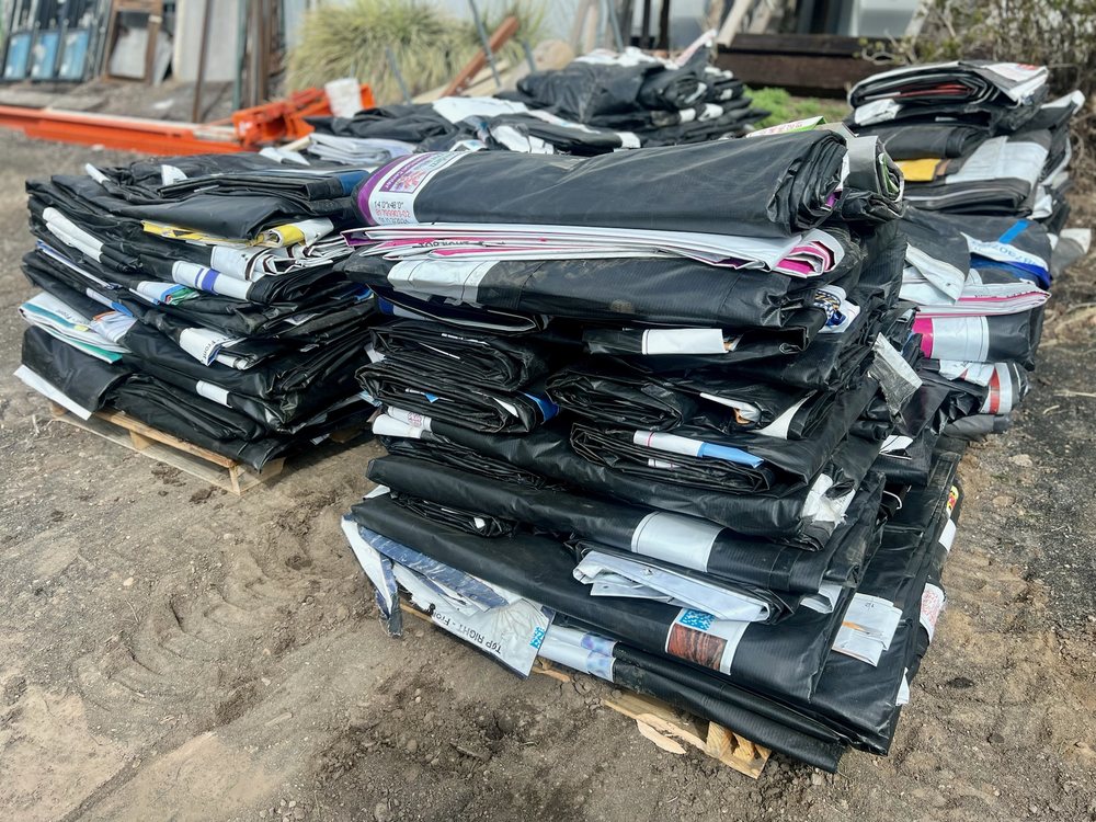 Stack of folded vinyl billboard tarps on a pallet in the Denver yard