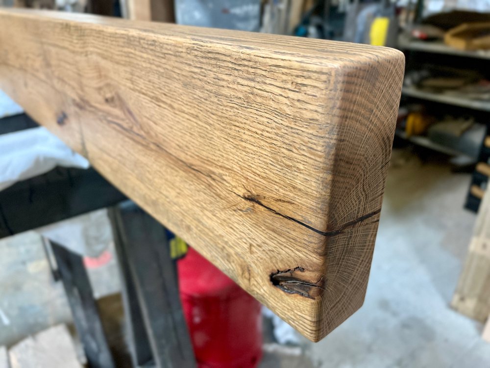 Thick hard oak transit board resting on a bench, open grain and hardware marks across the face