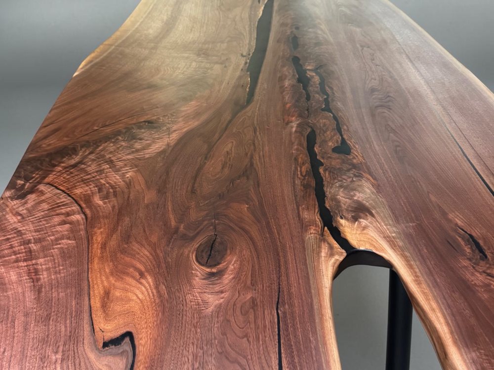 Wide black walnut slab standing upright, dark heartwood against pale sapwood and a natural edge