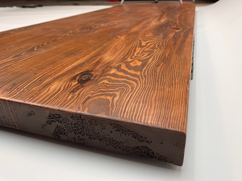 Thick Douglas fir board finished and standing on edge, tight grain and knots visible