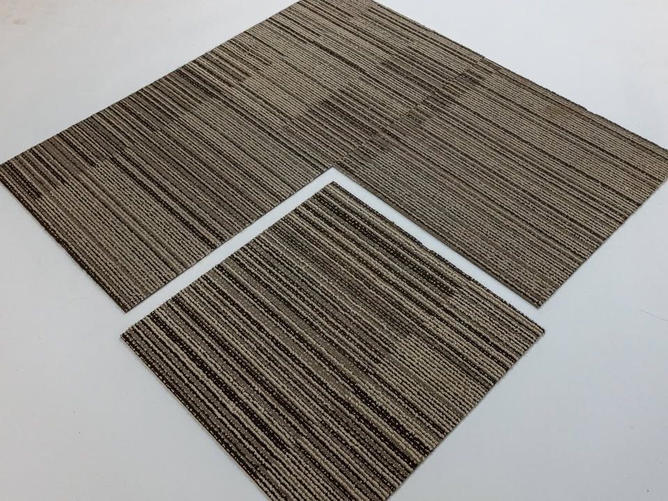 Two commercial carpet tiles laid together showing the linear pattern and the quarter-turn