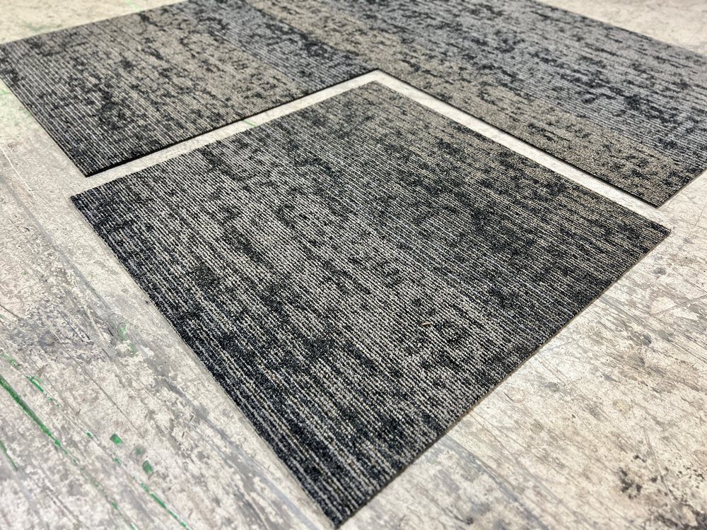 Grey and white commercial carpet tiles showing the pattern match