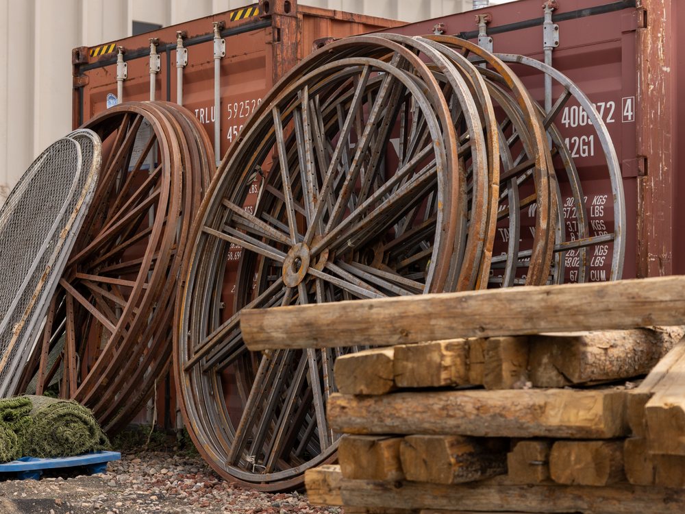 Cable spools and heavy timber stacked along the fence line