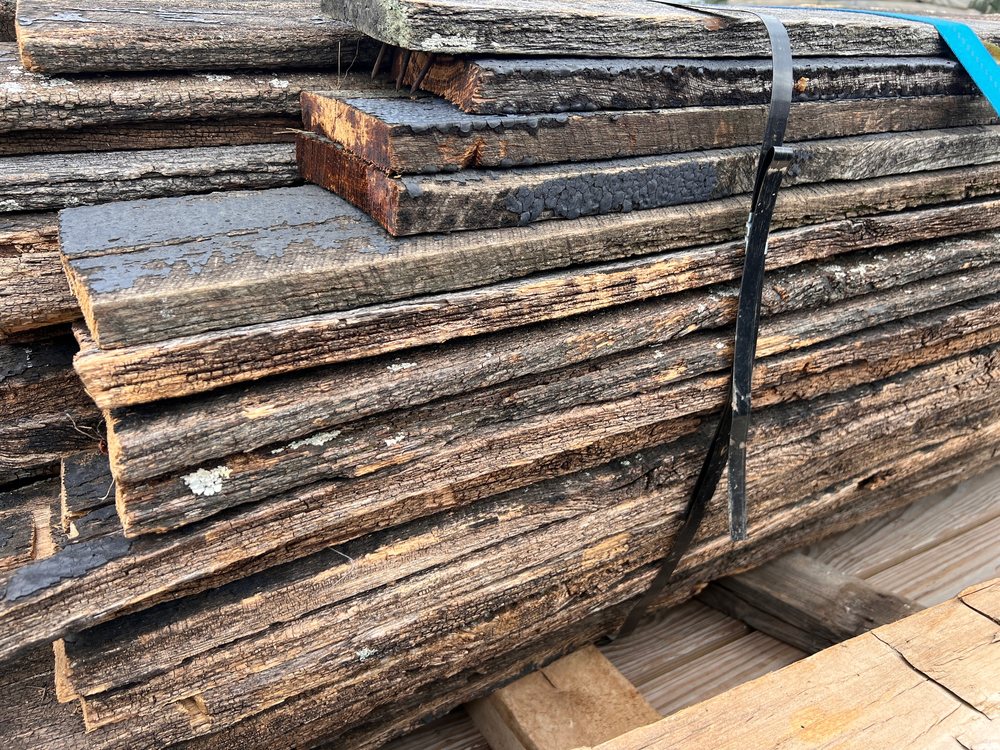 Banded bundle of Kentucky horse fence boards on a pallet, edge on, showing the one inch thickness