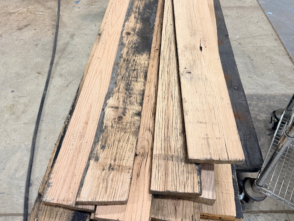 Horse fence boards laid out on the shop floor, weathered faces and clean oak backs side by side